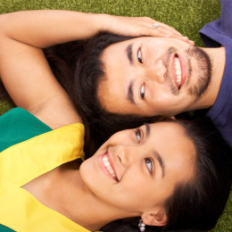 Boyfriend And Girlfriend Relaxing On The Grass In The Park